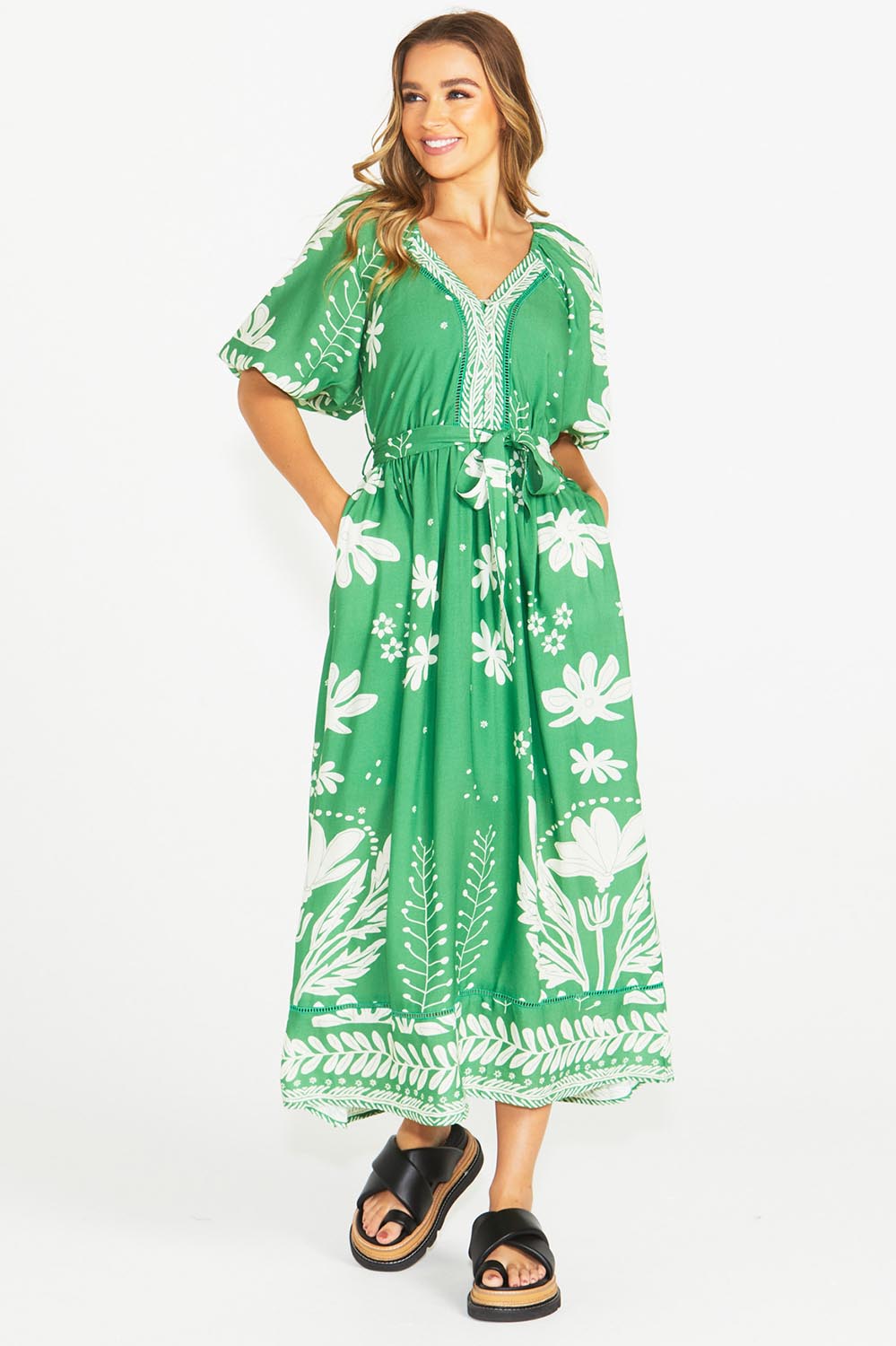 A model wearing the Lyndel Dress in colour Green (Green), from the front, showing the whole outfit