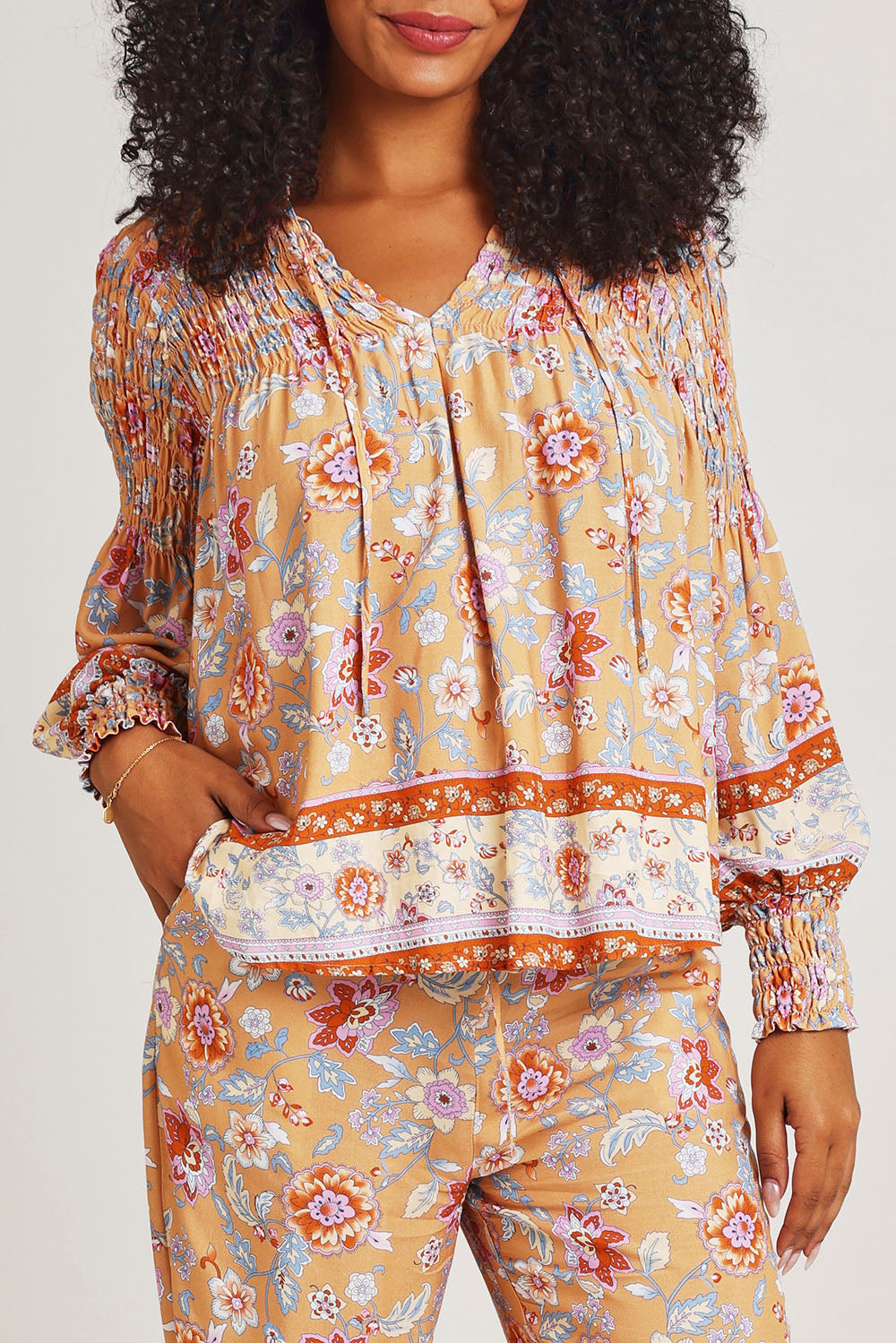 Model Ziara wearing size 10 of the Margie Top in colour Paisley, from the front, cropped image