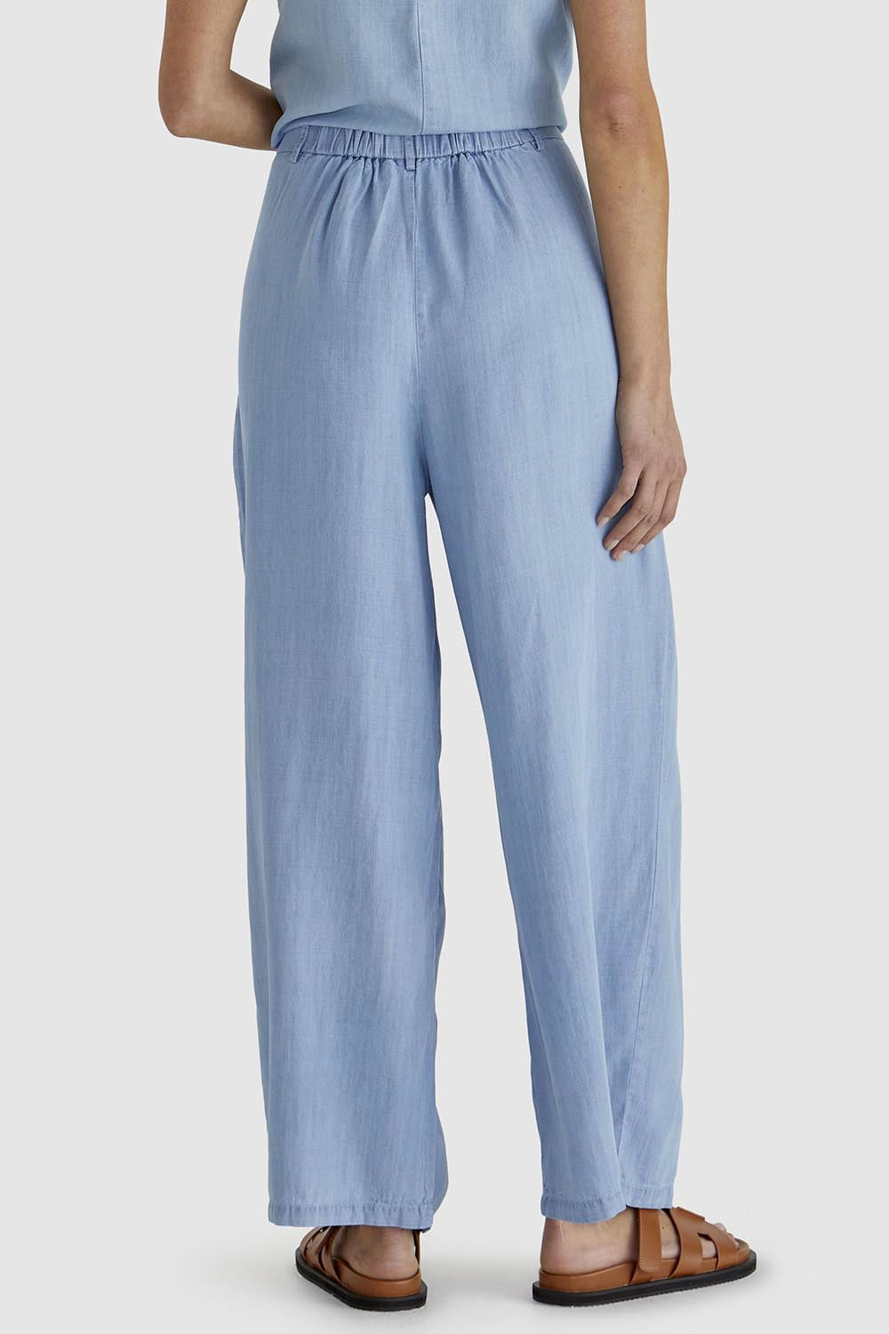 A model wearing the Rye Lyocell Pant in colour Chambray (Blue), from the back