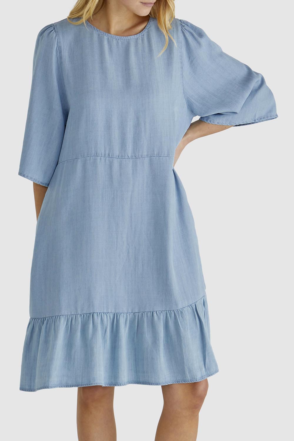 A model wearing the Rye Lyocell Dress in colour Chambray (Blue), from the front, cropped image