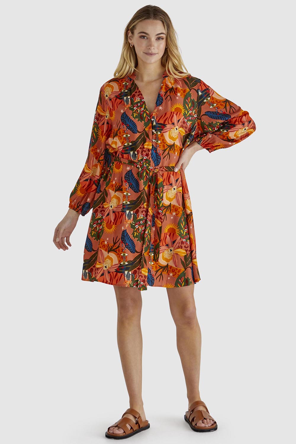 A model wearing the Zelda Dress in colour Desert, from the front, showing the whole outfit