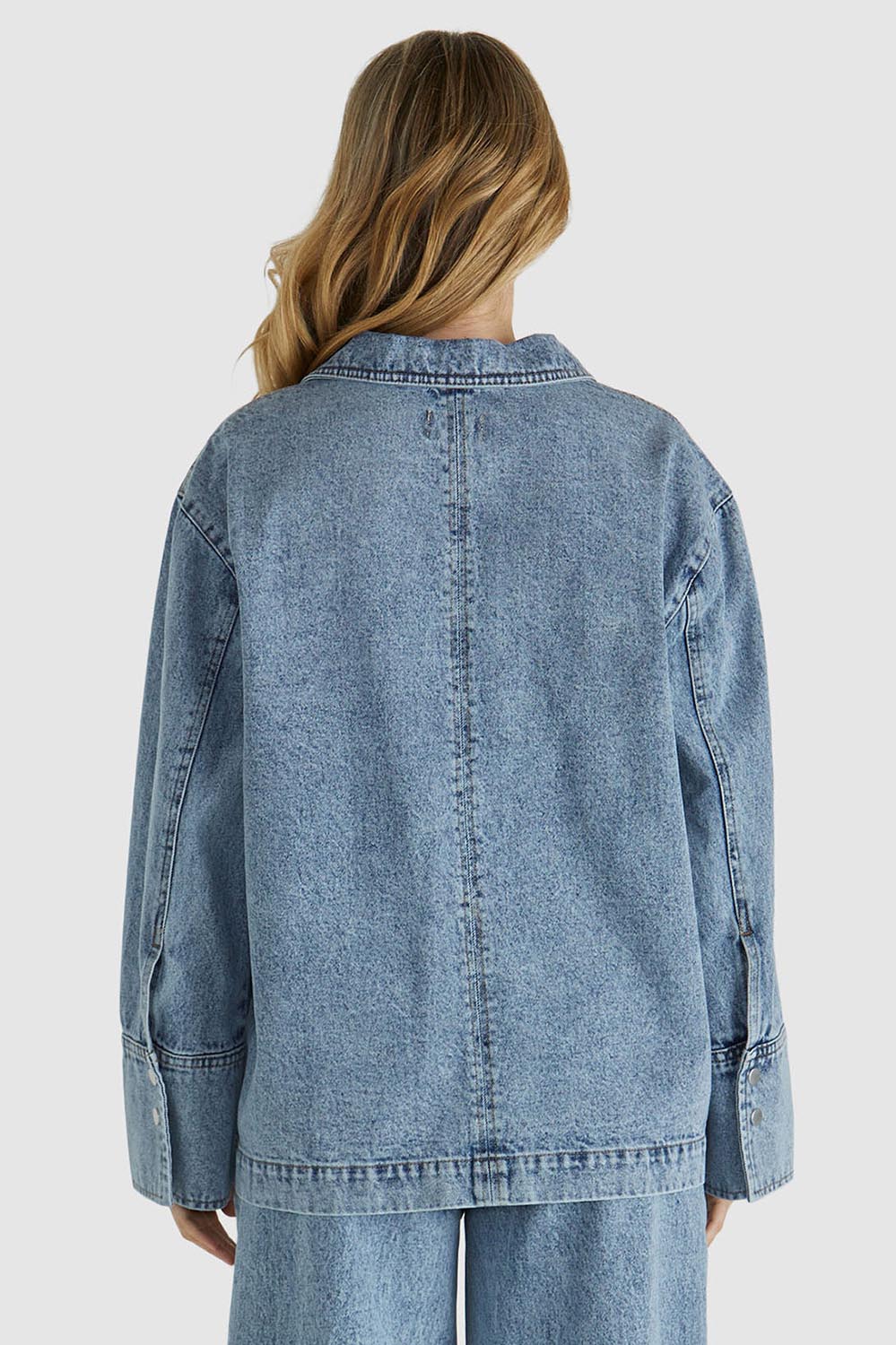 A model wearing the Jordon Top in colour Acidwash (Blue), from the back