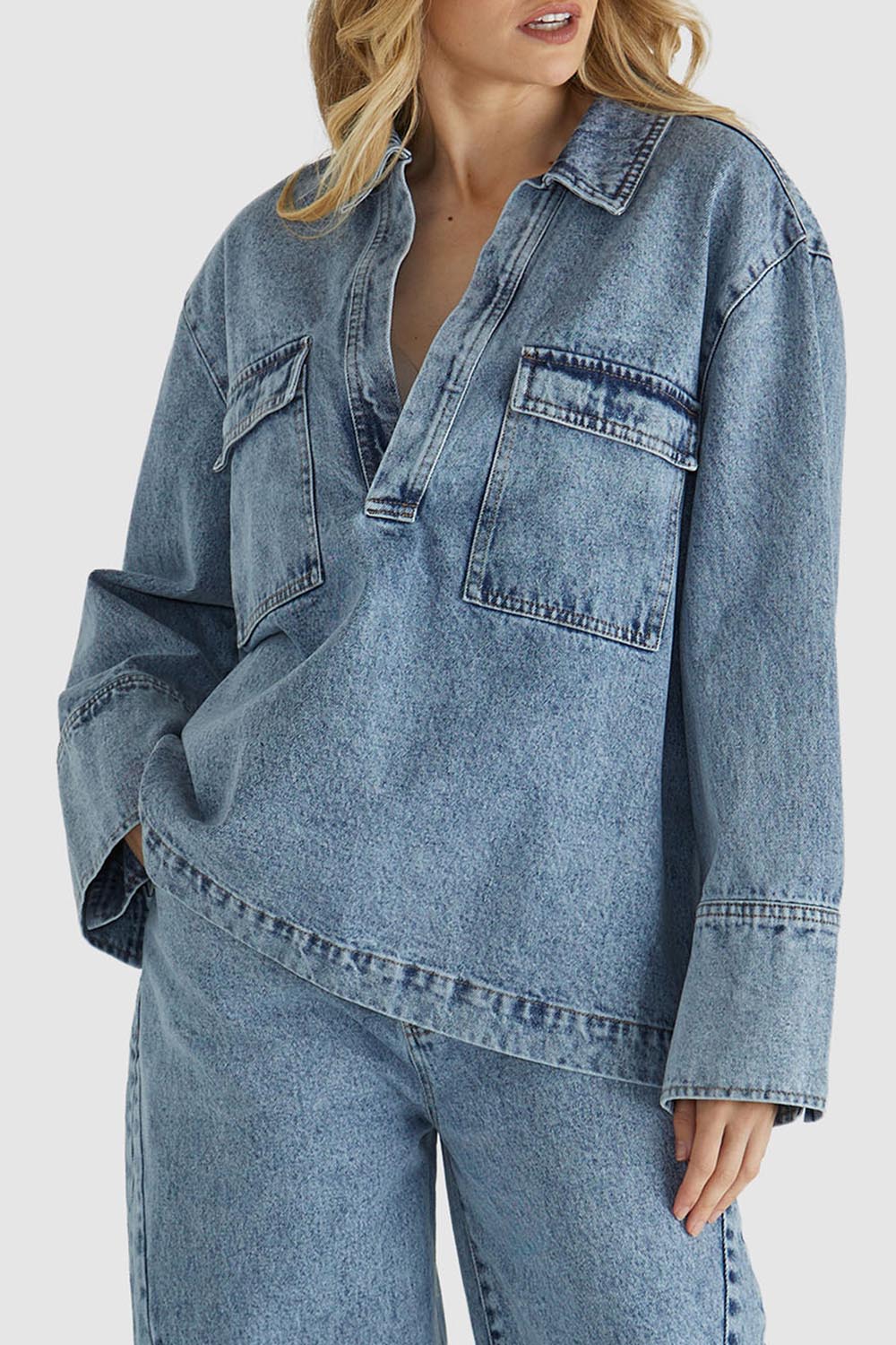 A model wearing the Jordon Top in colour Acidwash (Blue), from the front, cropped image
