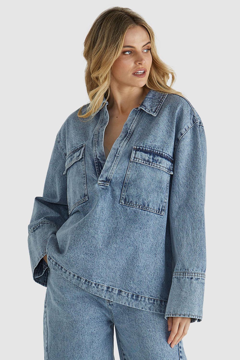 A model wearing the Jordon Top in colour Acidwash (Blue), from the front, cropped image