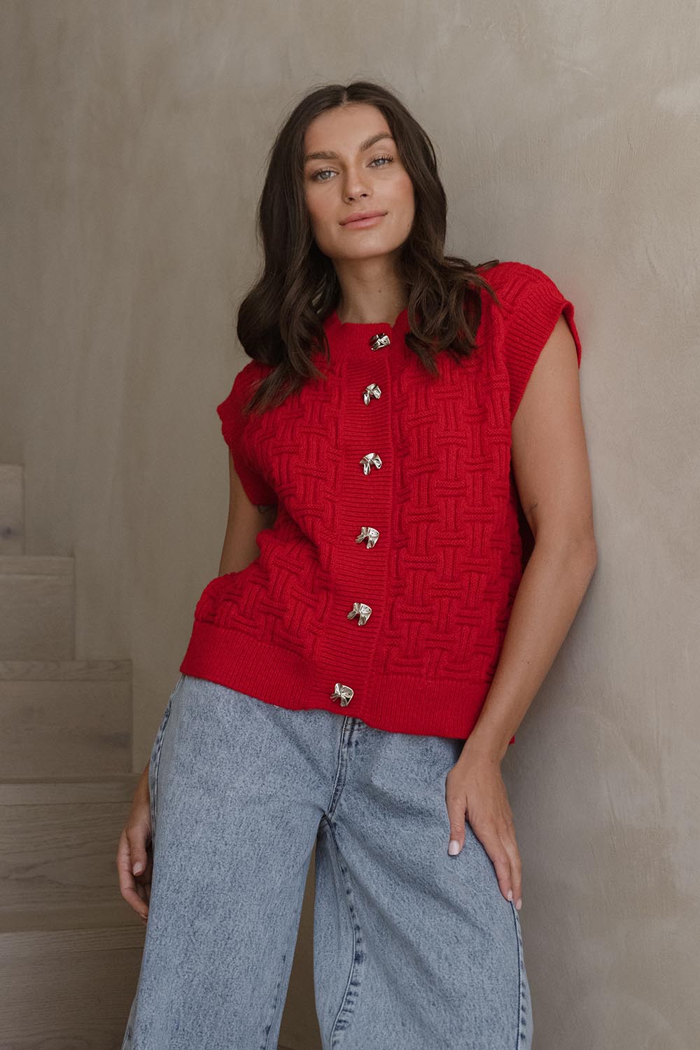 A model wearing the Zadie Vest in colour Poppyred (Red), from the front, showing the whole outfit