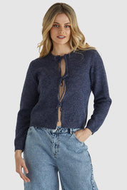 A model wearing the Greta Cardi in colour Navymarle (Blue), from the front, cropped image