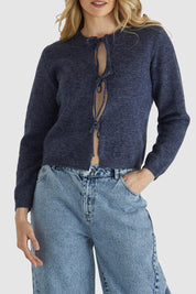 A model wearing the Greta Cardi in colour Navymarle (Blue), from the front, cropped image