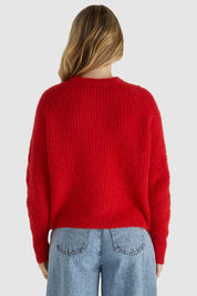 A model wearing the Romee Cardi in colour Poppyred (Red), from the back
