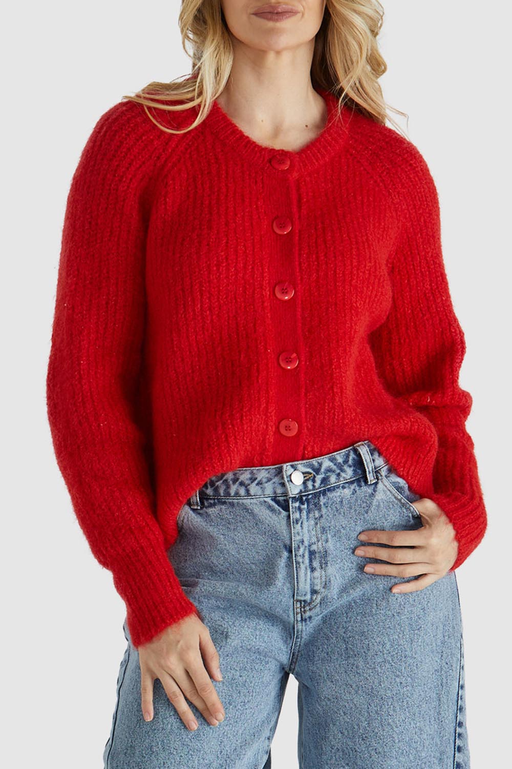 A model wearing the Romee Cardi in colour Poppyred (Red), from the front, cropped image