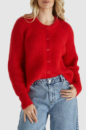 A model wearing the Romee Cardi in colour Poppyred (Red), from the front, cropped image