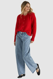 A model wearing the Romee Cardi in colour Poppyred (Red), from the front, showing the whole outfit