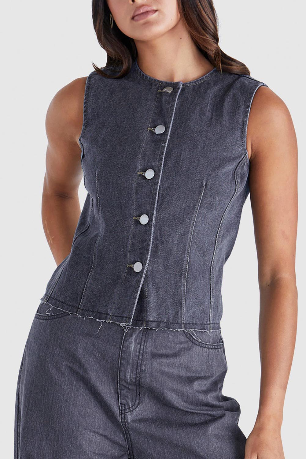 A model wearing the Ainsley Vest in colour Darkdenim (Black), from the front, cropped image