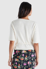 A model wearing the Casey Cardi in colour Cream (White), from the back