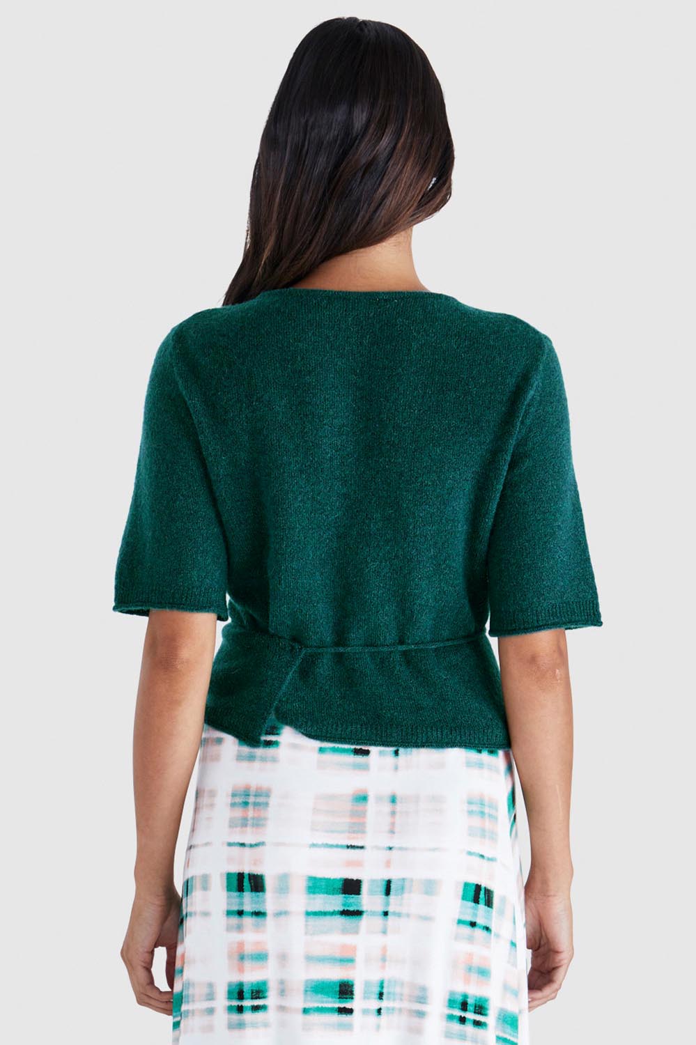 A model wearing the Casey Cardi in colour Teal (Green), from the back