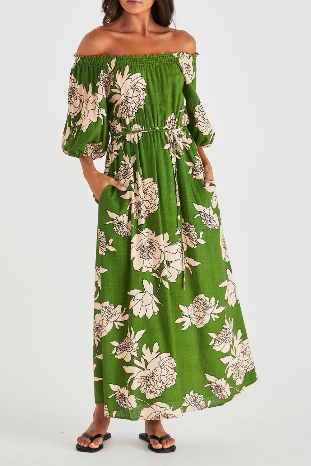 A model wearing the Antonie Off Shoulder Dress in colour Moonflower (Green), from the front, cropped image