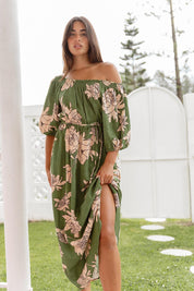 A model wearing the Antonie Off Shoulder Dress in colour Moonflower (Green), from the front, showing the whole outfit