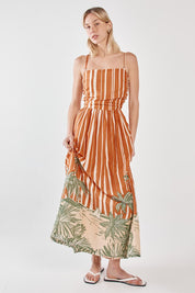 A model wearing the Mina Cotton Strapless Dress in colour Palmstripe, from the front, showing the whole outfit