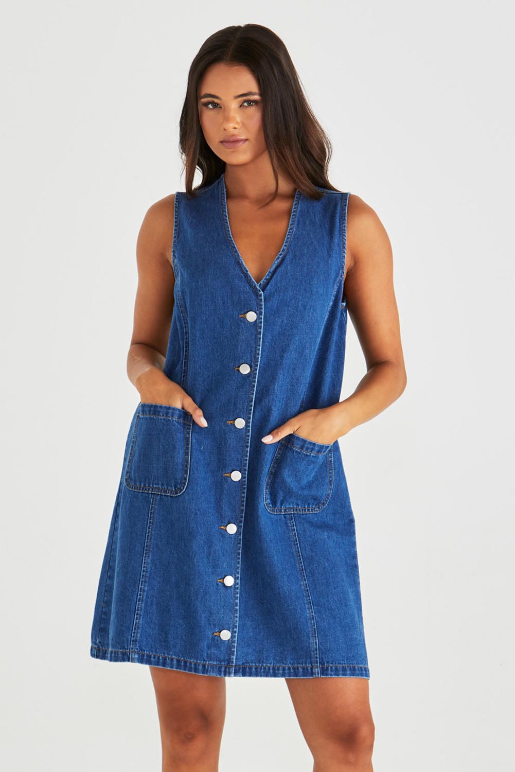 A model wearing the Sabine Denim Vest Dress in colour Midblue (Blue), from the front, cropped image