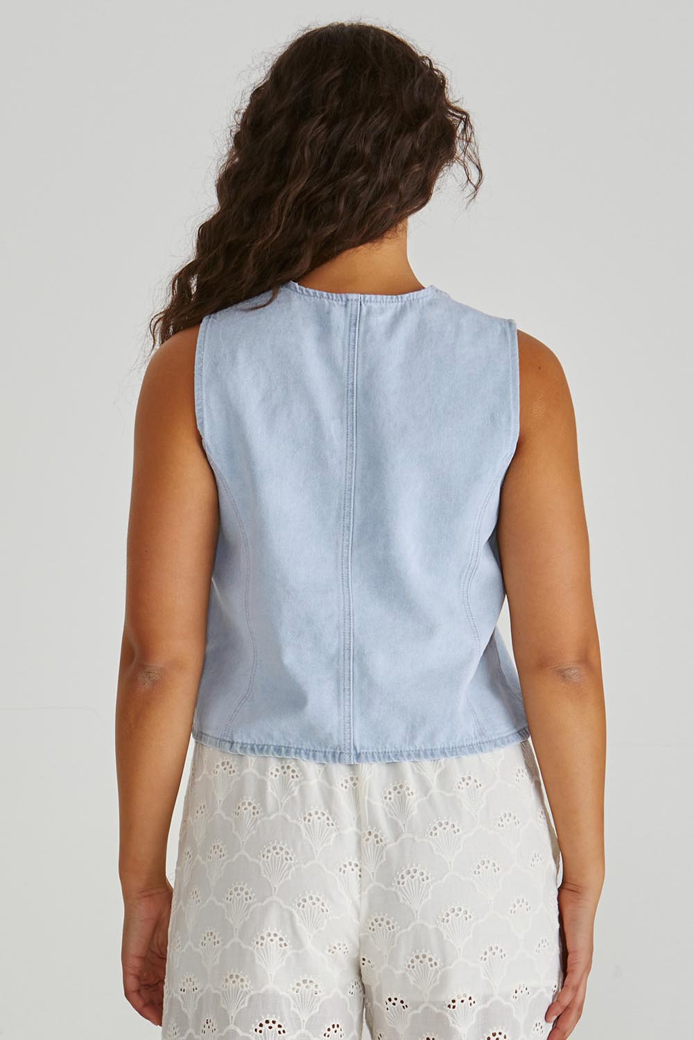 A model wearing the Sabine Denim Vest in colour Bleach (Blue), from the back