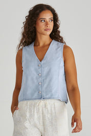 A model wearing the Sabine Denim Vest in colour Bleach (Blue), from the front, cropped image