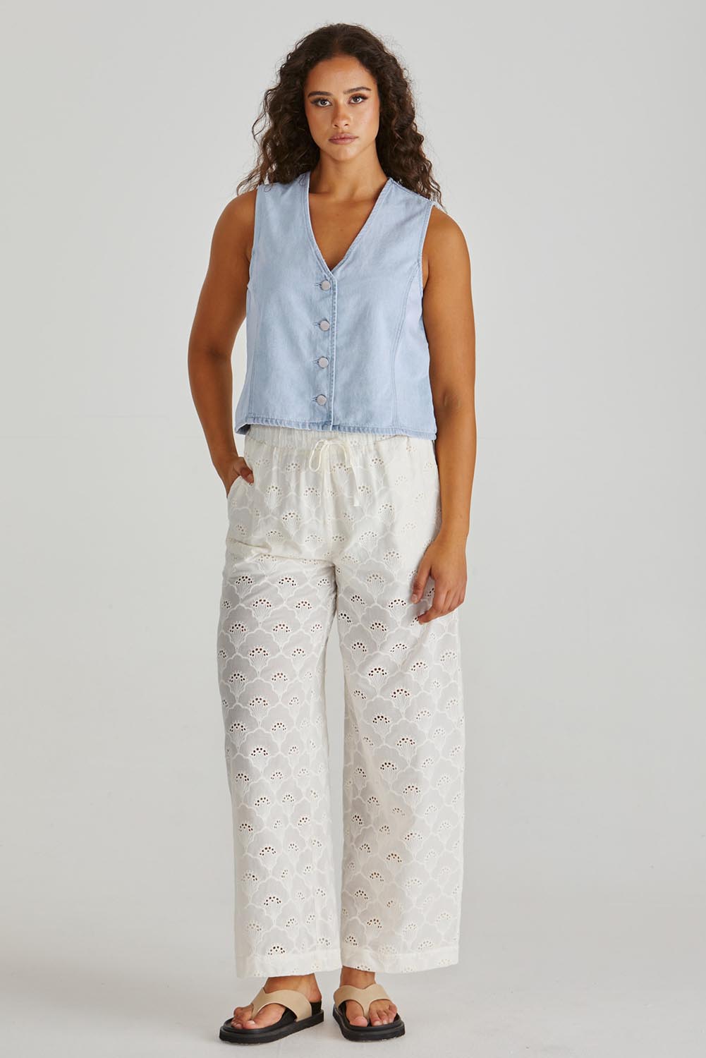 A model wearing the Sabine Denim Vest in colour Bleach (Blue), from the front, showing the whole outfit