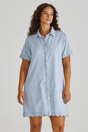 A model wearing the Vale Scalloped Denim Dress in colour Bleach (Blue), from the front, cropped image