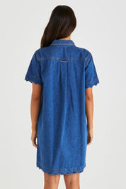 A model wearing the Vale Scalloped Denim Dress in colour Midblue (Blue), from the back