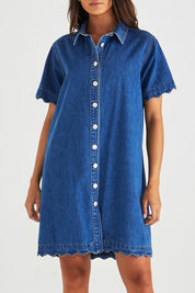 A model wearing the Vale Scalloped Denim Dress in colour Midblue (Blue), from the front, cropped image