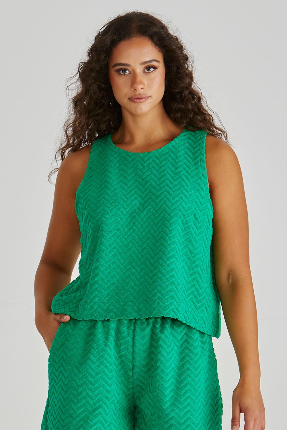 A model wearing the Codi Cotton Blend Tank in colour Green (Green), from the front, cropped image