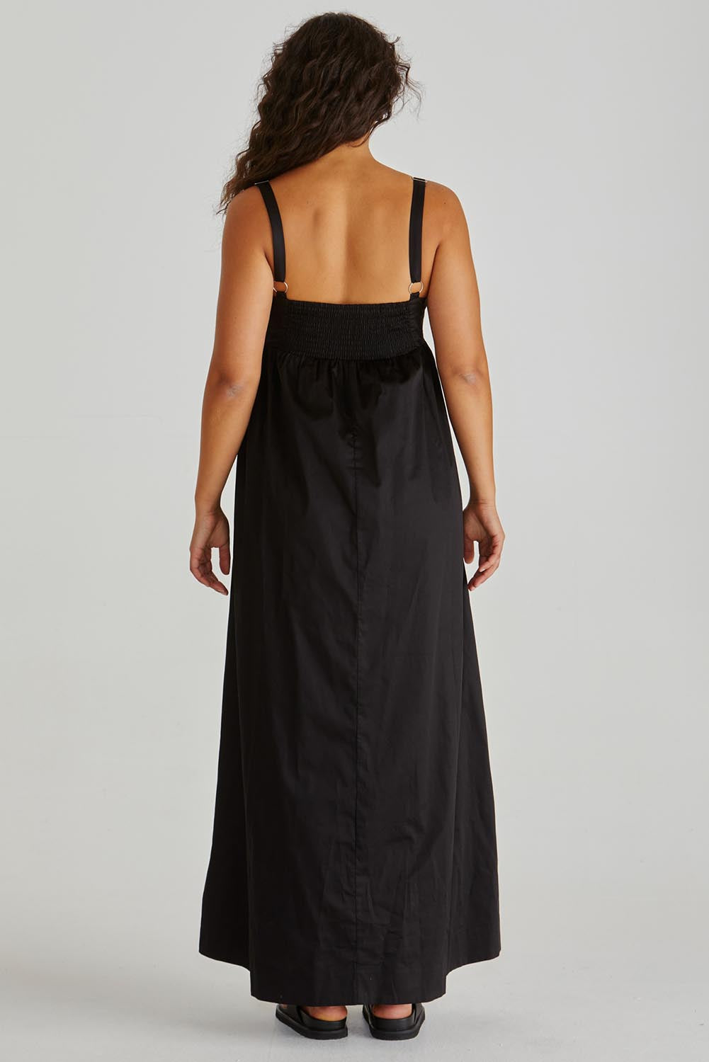 A model wearing the Delaney Cotton Maxi Dress in colour Black (Black), from the back