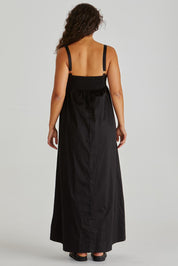 A model wearing the Delaney Cotton Maxi Dress in colour Black (Black), from the back