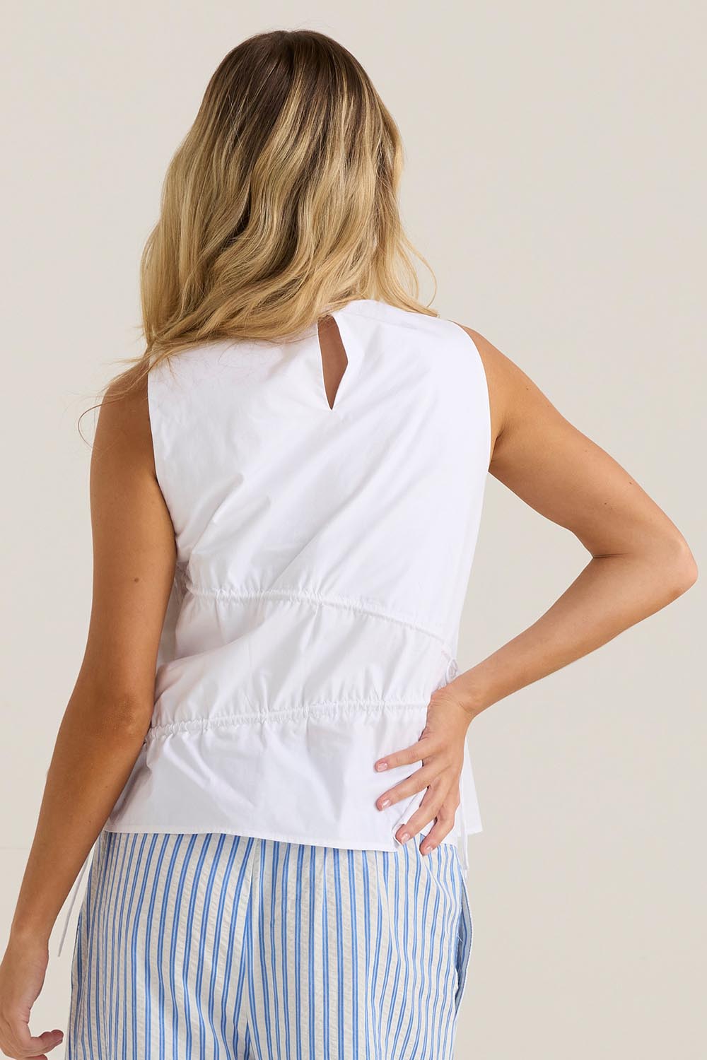 A model wearing the Elin Gathered Tie Top in colour White (White), from the back