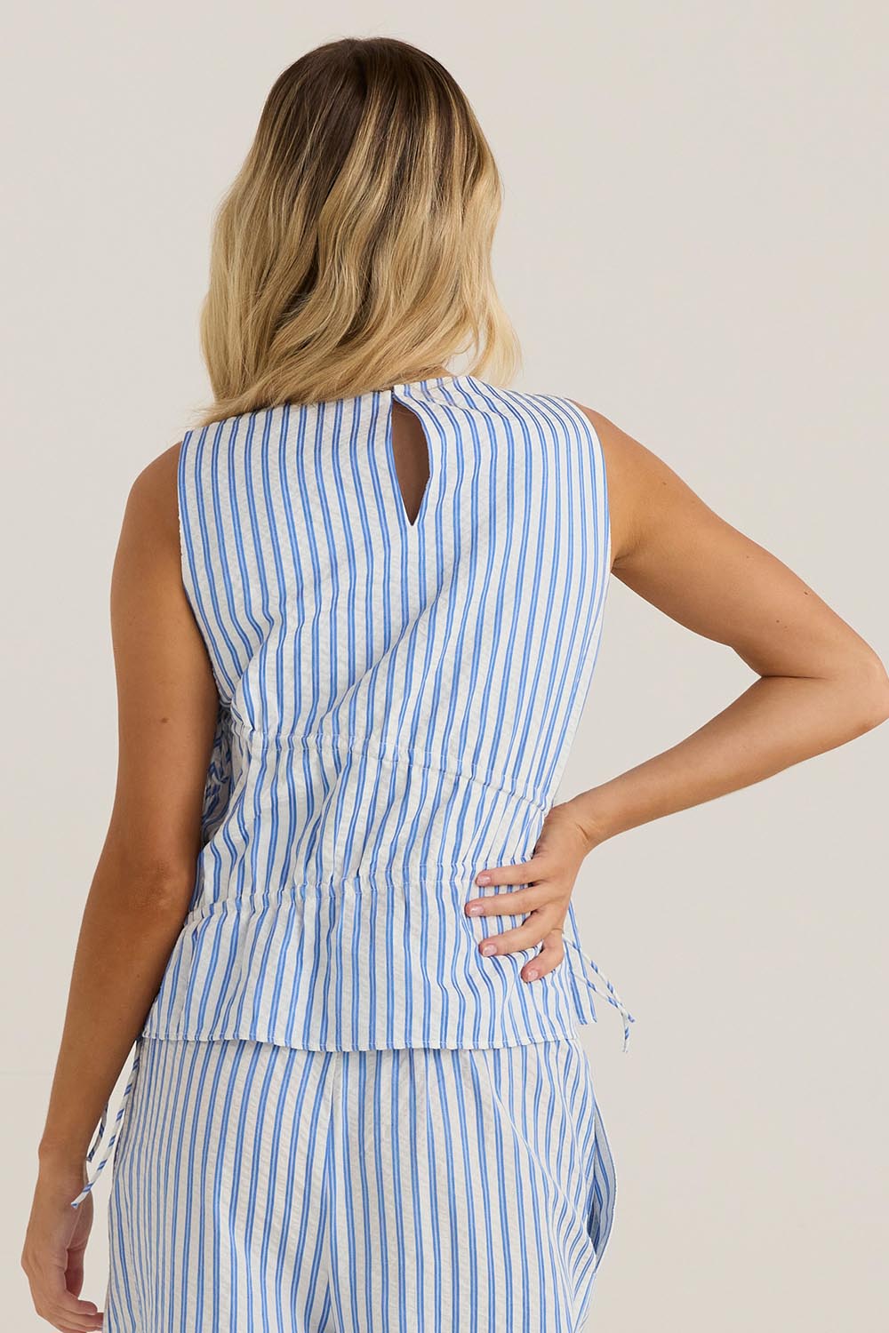 A model wearing the Aziza Gathered Tie Top in colour Bluewhite (Blue), from the back