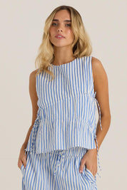 A model wearing the Aziza Gathered Tie Top in colour Bluewhite (Blue), from the front, cropped image