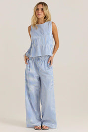 A model wearing the Aziza Gathered Tie Top in colour Bluewhite (Blue), from the front, showing the whole outfit