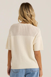 A model wearing the Cherri Top in colour Cream, from the back