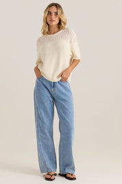 A model wearing the Cherri Top in colour Cream, from the front, showing the whole outfit