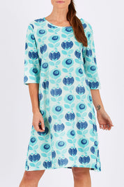 Model Monique wearing size 10 of the Vacker Dress in colour BlueFlower (Blue), from the front, cropped image