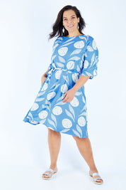 Model Lauren wearing size 16 of the Solnedgang Dress in colour Circflwr (Blue), from the front, showing the whole outfit
