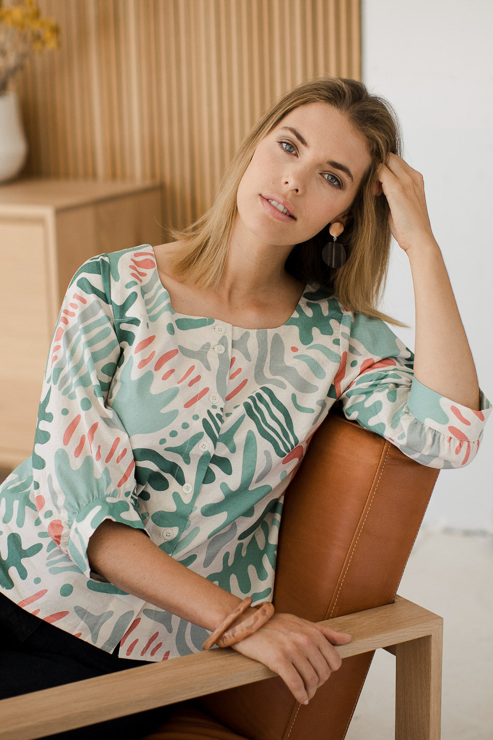 Model Phoebe wearing size 10 of the Fyrkant Neck Blouse in colour Splatter (Green), from the front, showing the whole outfit