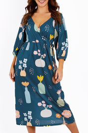 Model Jessica wearing size 14 of the Romantik Dress in colour Vases (Blue), from the front, cropped image