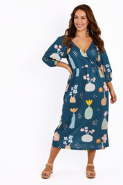 Model Jessica wearing size 14 of the Romantik Dress in colour Vases (Blue), from the front, showing the whole outfit