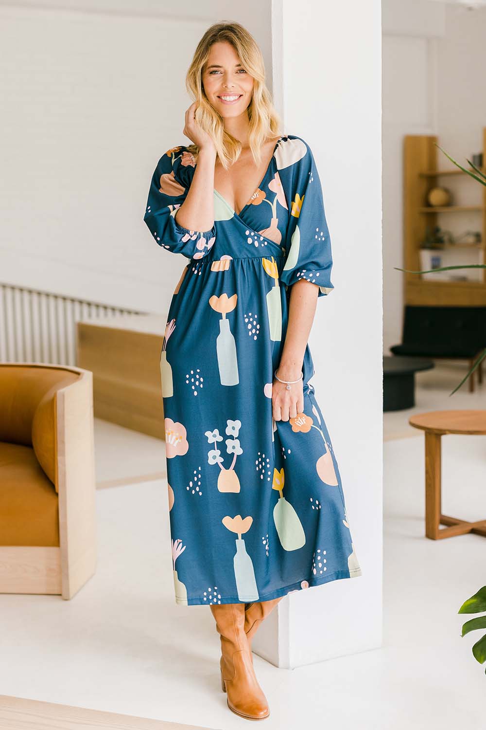 Model Phoebe wearing size 10 of the Romantik Dress in colour Vases (Blue), from the front, showing the whole outfit