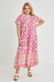 Model Keeara wearing size 16 of the Kurrawa Beach Long Cotton Dress in colour Pinkorange (Pink), from the front, showing the whole outfit