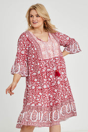 Model Keeara wearing size 16 of the Tallows Beach Cotton Dress in colour Red (Red), from the front, cropped image