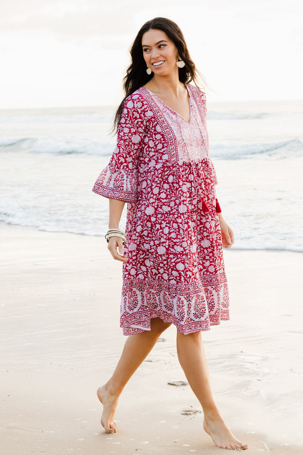 Model Stacey wearing size 10 of the Tallows Beach Cotton Dress in colour Red (Red), from the front, showing the whole outfit