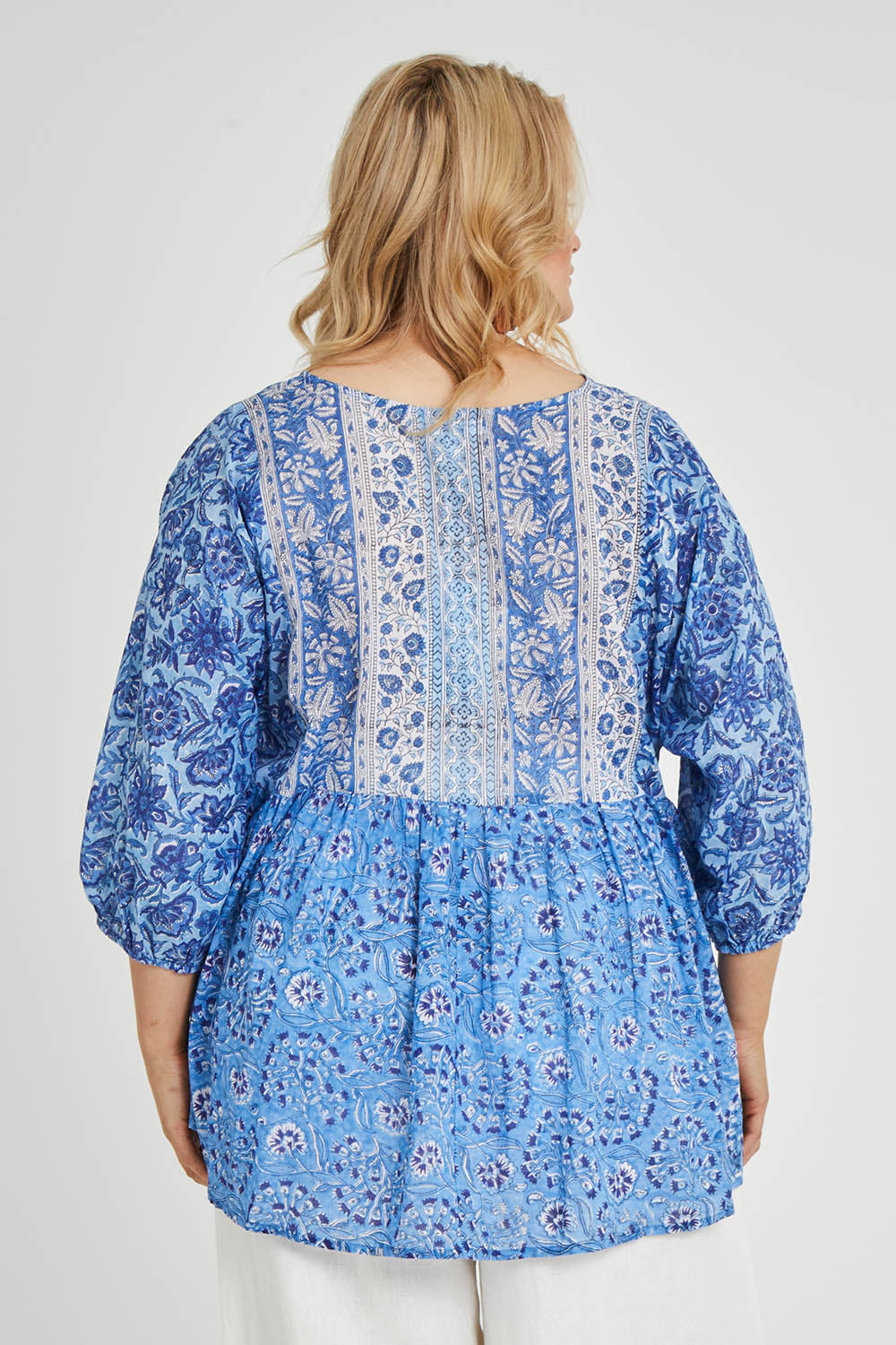 Model Keeara wearing size 16 of the Rosebud Beach Cotton Blouse in colour Blue (Blue), from the back