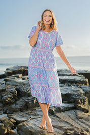 Model Riina wearing size 10 of the Bilgola Beach Cotton Dress in colour Bluepink (Blue), from the front, showing the whole outfit