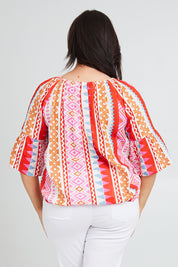 Model Poppy wearing size 16 of the Aslings Beach Cotton Blouse in colour Multipink (Pink), from the back