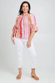 Model Poppy wearing size 16 of the Aslings Beach Cotton Blouse in colour Multipink (Pink), from the front, showing the whole outfit